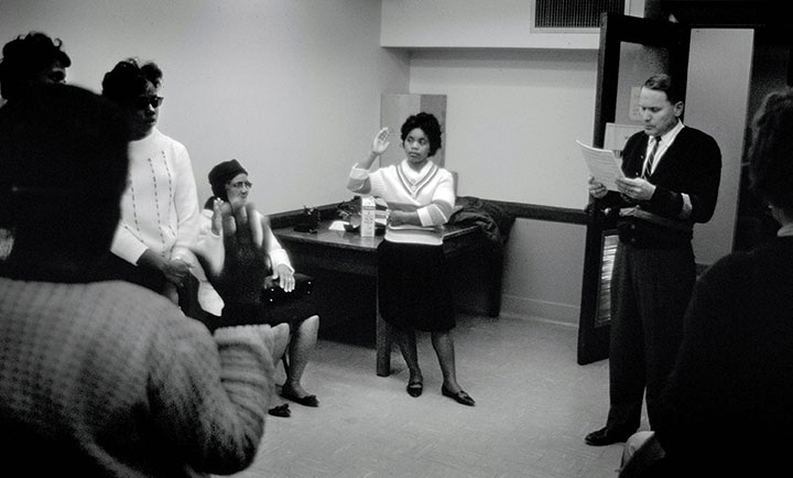 Black women are pictured as they swear an oath during the voter registration process in Mississippi.